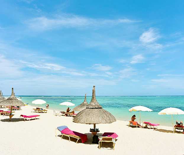 En strand med parasoller og liggestole ved havet. (AI-genereret tekst)