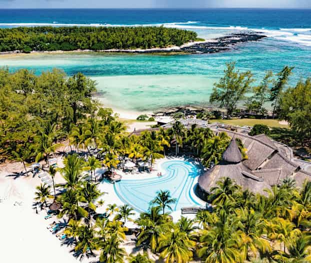 Strand- og poolområde med palmer og turkis vand. (AI-genereret tekst)