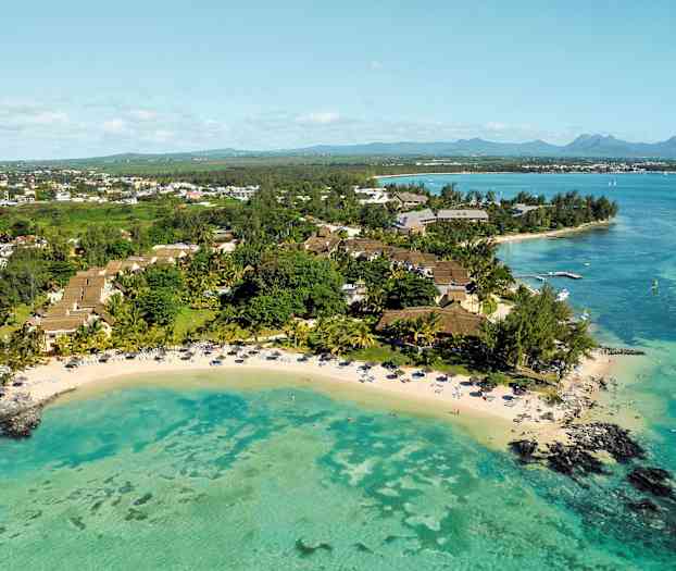 Luftfoto af et tropisk resort ved en strand med turkisfarvet vand. (AI-genereret tekst)