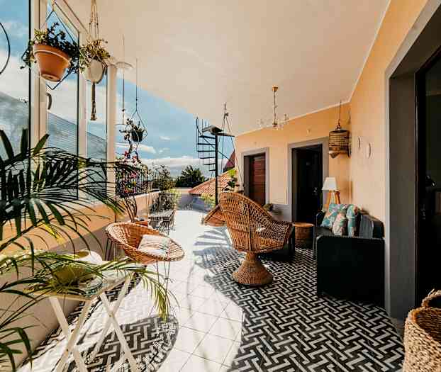 En møbleret og dekoreret terrasse med planter. (AI-genereret tekst)