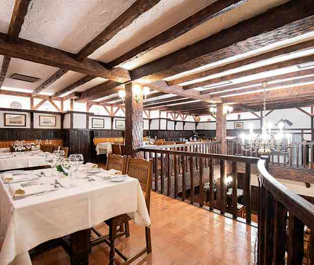 Rustik restaurant med træbjælker og dækkede borde. (AI-genereret tekst)