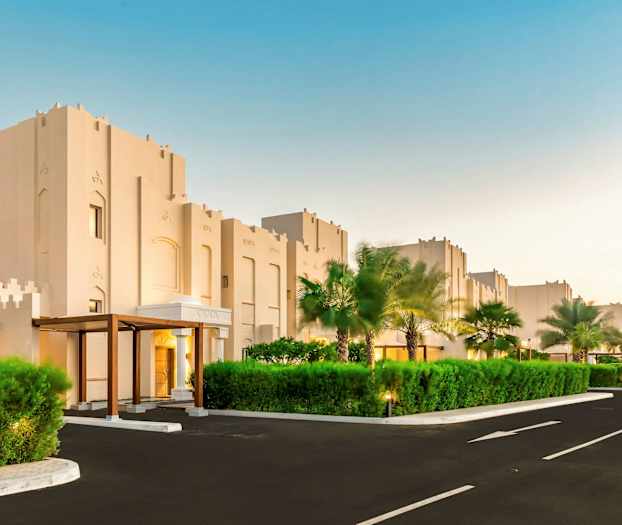 Bygninger med moderne arkitektur og omkringliggende grønne områder. (AI-genereret tekst)