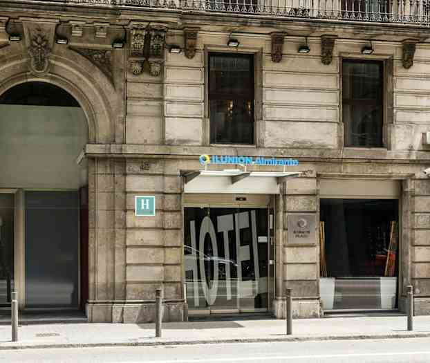 En hotelfacade af Ilunion Almirante med indgang og skilt. (AI-genereret tekst)