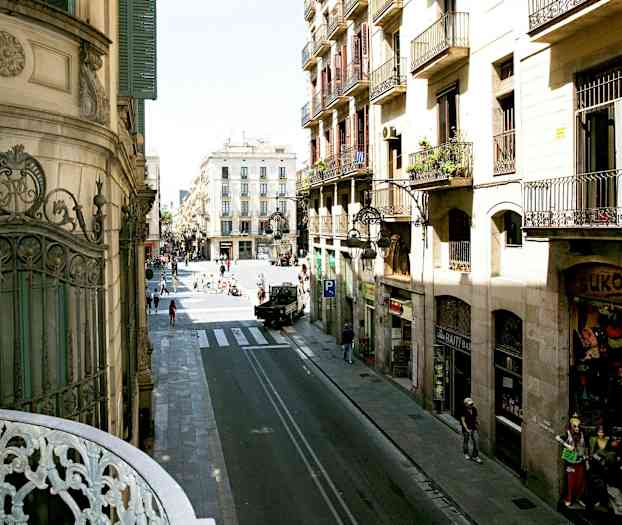 Udsigt over gade med bygninger og mennesker i bymiljø. (AI-genereret tekst)