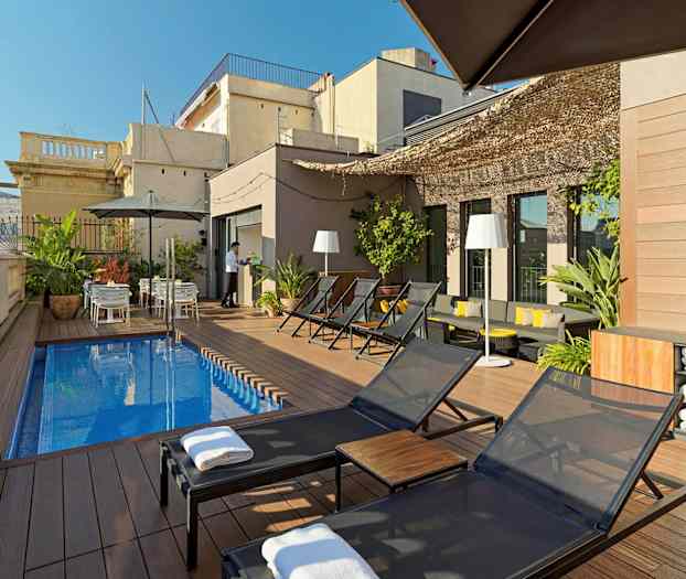 En tagterrasse med liggestole, et lille rektangulært poolområde, planter og borde med parasoller. (AI-genereret tekst)