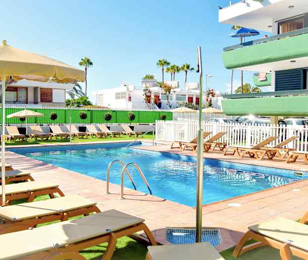 Udendørspool med liggestole og parasoller ved et lejlighedskompleks. (AI-genereret tekst)