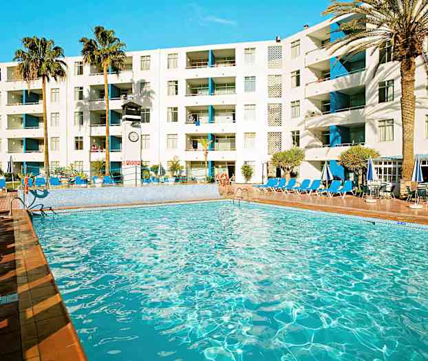 En pool ved et hotel med liggestole, parasoller og palmer i baggrunden. (AI-genereret tekst)