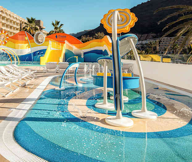 Børnepool med vandlege og liggestole i hotelområdet. (AI-genereret tekst)