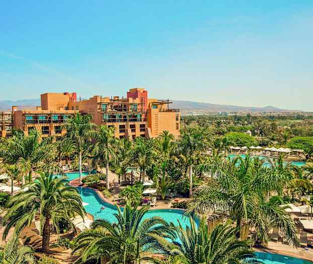 Et feriested med pools og omgivelser af palmer samt bygninger i baggrunden. (AI-genereret tekst)