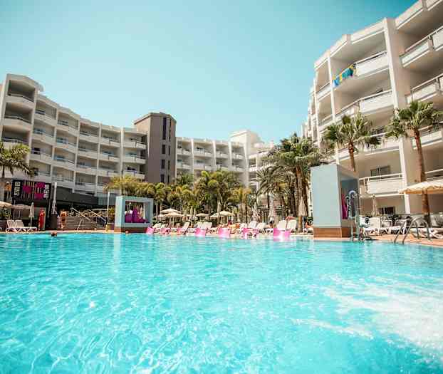 En hotelpool ved et større bygningskompleks. (AI-genereret tekst)