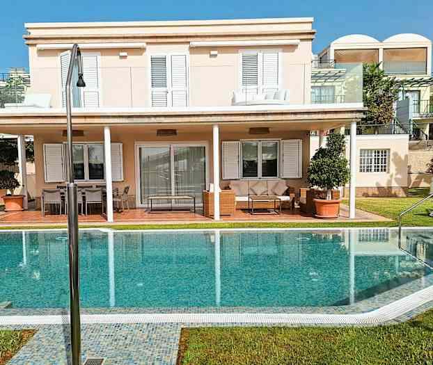 En villa med to etager, solterrasse og pool. (AI-genereret tekst)