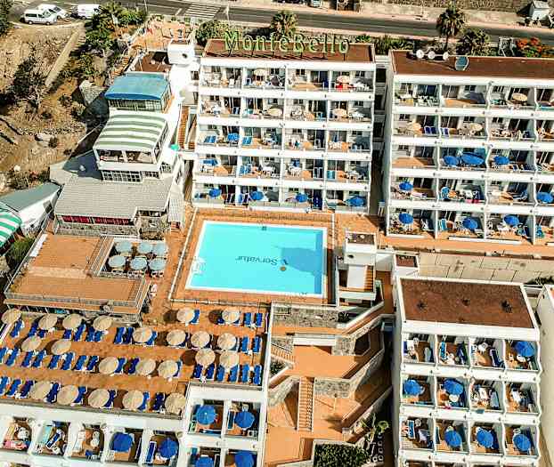 Luftfoto af hotel Montebello med pool og liggestole. (AI-genereret tekst)