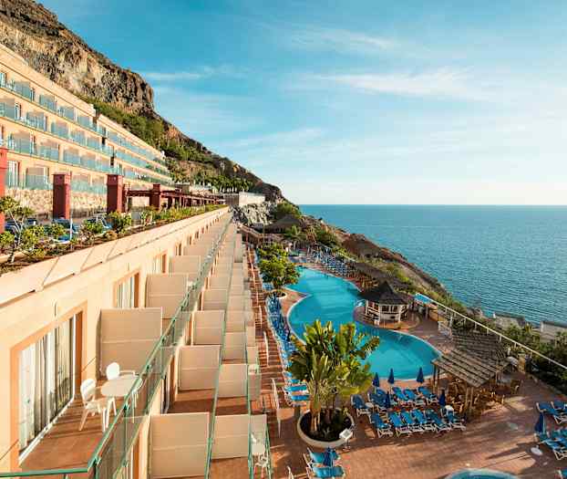 Et hotel med altaner, swimmingpools og havudsigt. (AI-genereret tekst)