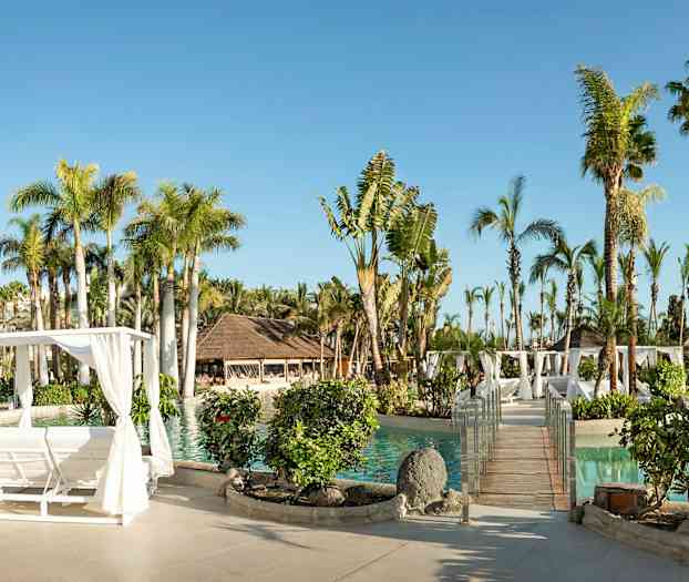 Solrigt feriested med pool, palmer, træpergola og beplantninger. (AI-genereret tekst)