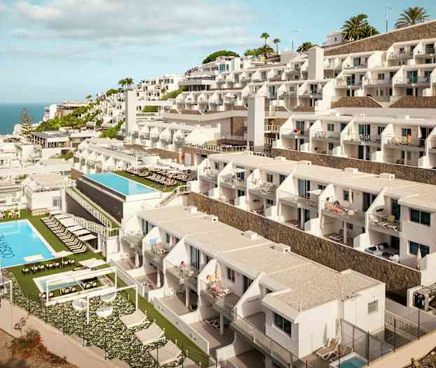 Hotelbygning med flere etager og pools mod havet. (AI-genereret tekst)