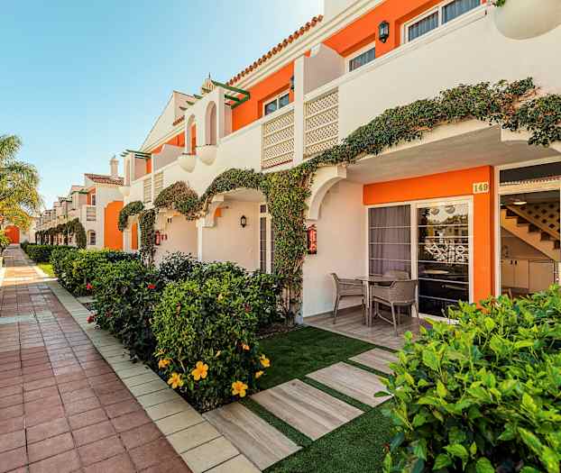 Række af ferielejligheder med private terrasser og have. (AI-genereret tekst)