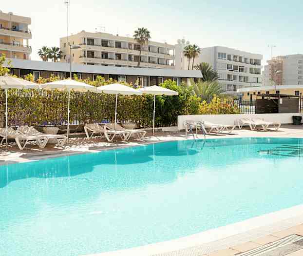 Udendørspool med liggestole og parasoller på poolområdet. (AI-genereret tekst)