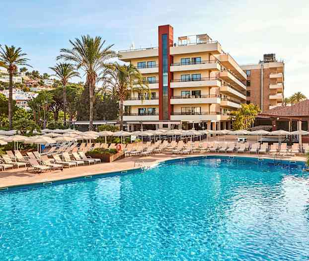 Billede af en hotelbygning omgivet af palmer, med en swimmingpool og liggestole i forgrunden. (AI-genereret tekst)