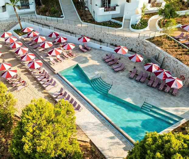 Poolområde med liggestole og røde parasoller. (AI-genereret tekst)