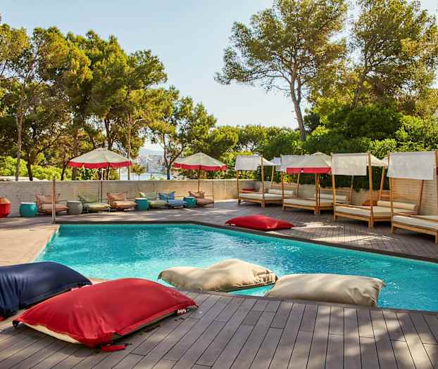 En udendørs pool omgivet af liggestole og parasoller. (AI-genereret tekst)