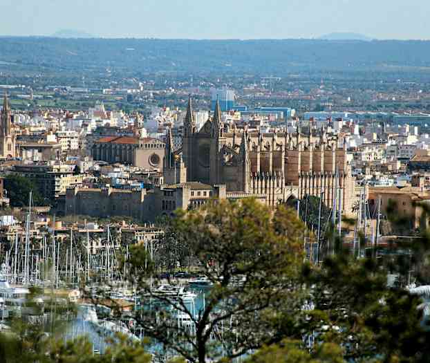 Billede af en by med en katedral i centrum og en marina i forgrunden. (AI-genereret tekst)