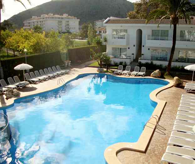 Stor pool omgivet af liggestole og parasoller ved et hotel. (AI-genereret tekst)