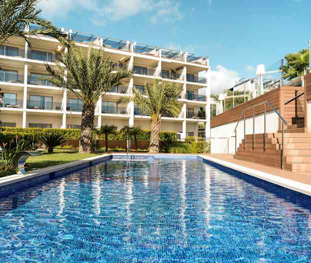 Billede af en udendørs pool med palmer og en moderne bygning i baggrunden. (AI-genereret tekst)