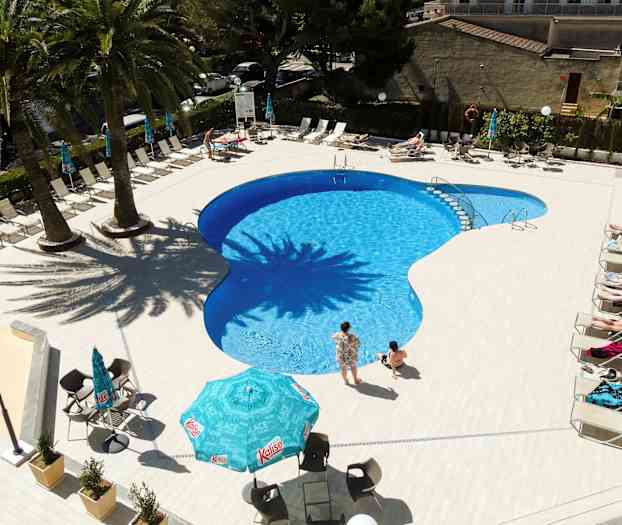 Udendørs swimmingpool med liggestole og parasoller omkring. (AI-genereret tekst)