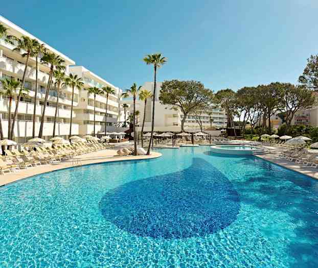 En solrig pool omgivet af liggestole, parasoller og palmer ved et hotel. (AI-genereret tekst)