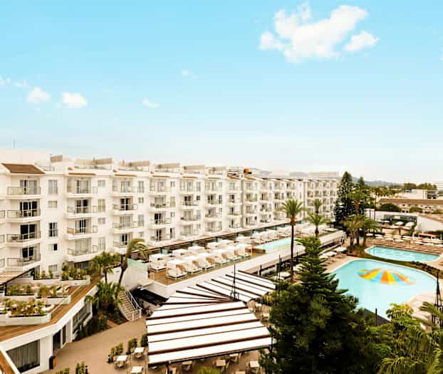 Billede af et hotel med poolområde og liggestole. (AI-genereret tekst)