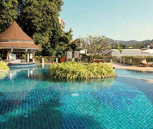 Poolområde med en ø med planter og et tag med havemøbler. (AI-genereret tekst)