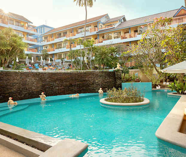 Hotel med poolområde med liggestole og parasoller. (AI-genereret tekst)