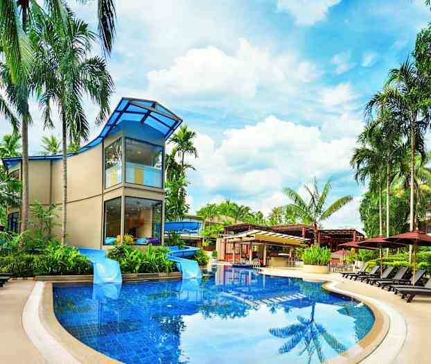 En moderne bygning omgivet af palmer og liggestole ved en swimmingpool. (AI-genereret tekst)