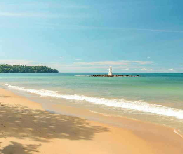 En strand med sand og bølger samt et fyrtårn på en mindre ø. (AI-genereret tekst)