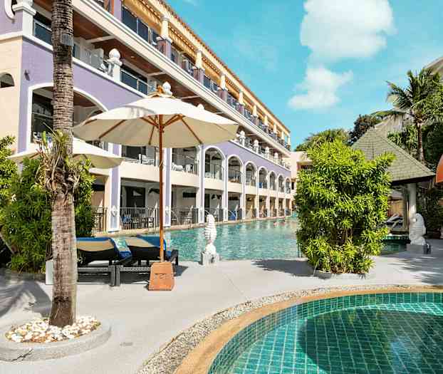 En pool med liggestole og parasoller ved siden af en hotelbygning. (AI-genereret tekst)