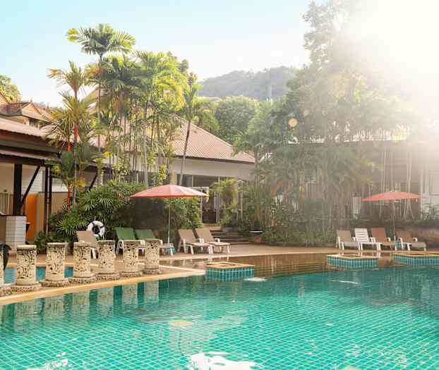 Udendørs pool med liggestole og parasoller, omgivet af frodige træer. (AI-genereret tekst)