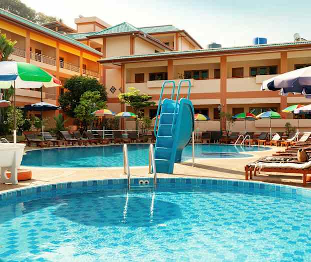 Hotel poolområde med liggestole og parasoller. (AI-genereret tekst)