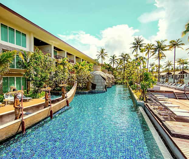 Hotelområde med swimmingpool, omgivet af palmer og solsenge. (AI-genereret tekst)