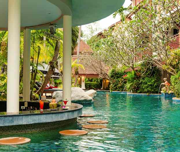 En pool med et barområde omgivet af grønne omgivelser. (AI-genereret tekst)