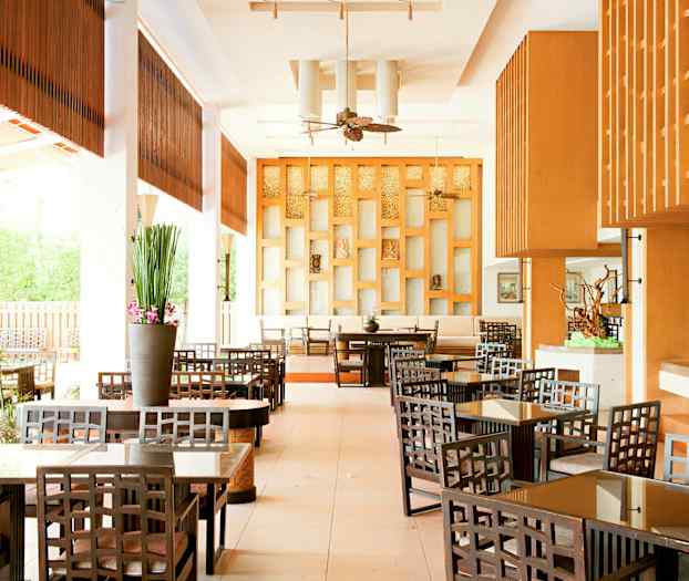 En elegant hotelcafé med træmøbler og moderne indretning. (AI-genereret tekst)