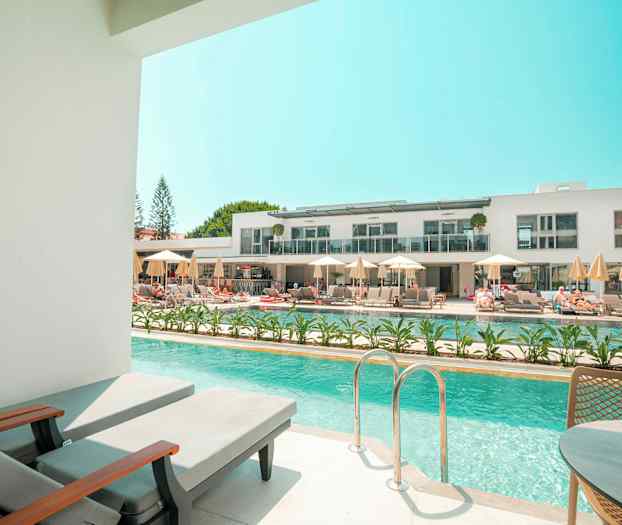 Privat poolområde med udsigt til et moderne hotelkompleks. (AI-genereret tekst)