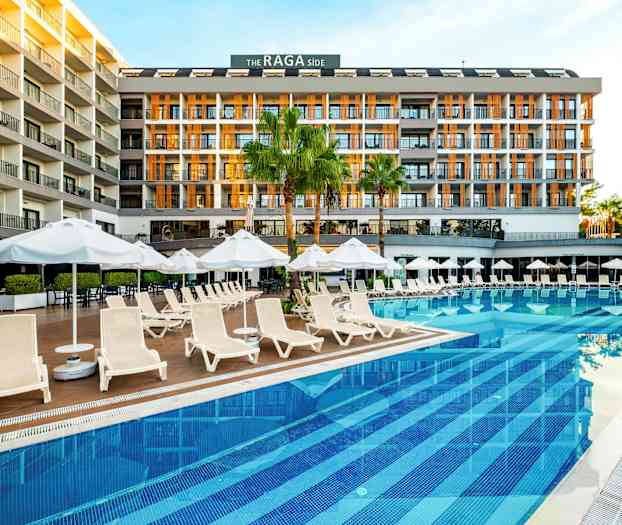 Et hotel ved en pool med liggestole og parasoller. (AI-genereret tekst)