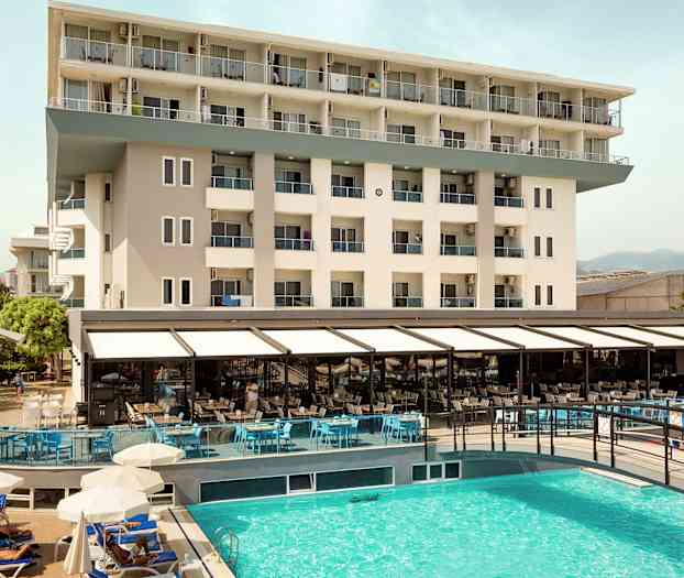 Udsigt over hotelbygning og udendørs pool. (AI-genereret tekst)