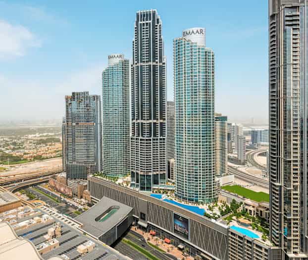 Et bybillede med flere høje skyskrabere og en motorvej i forgrunden. (AI-genereret tekst)