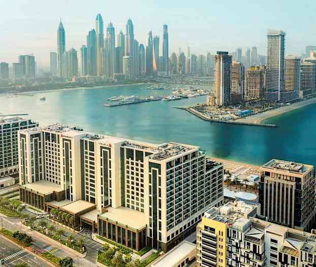 Byudsigt over moderne bygninger og en havn ved vandet. (AI-genereret tekst)