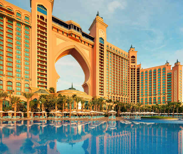 Stor bygning med bue og pool foran. (AI-genereret tekst)