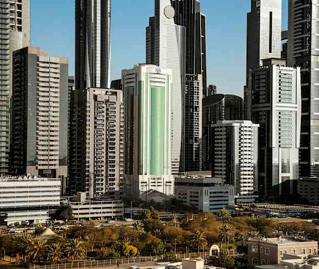 Høje moderne bygninger omgivet af grønne områder og parker. (AI-genereret tekst)