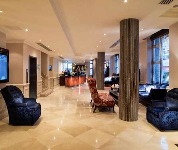 Hotellets lobby med siddegrupper og reception. (AI-genereret tekst)