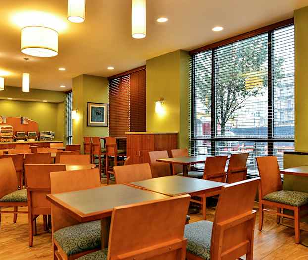 En restaurant med borde, stole og en serveringsdisk. (AI-genereret tekst)