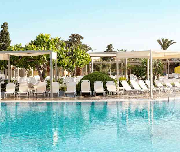 En pool med liggestole og skyggefulde pavilloner i baggrunden. (AI-genereret tekst)